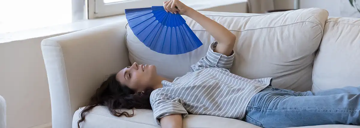 Girl lying on sofa wondering why her AC is not blowing cold air