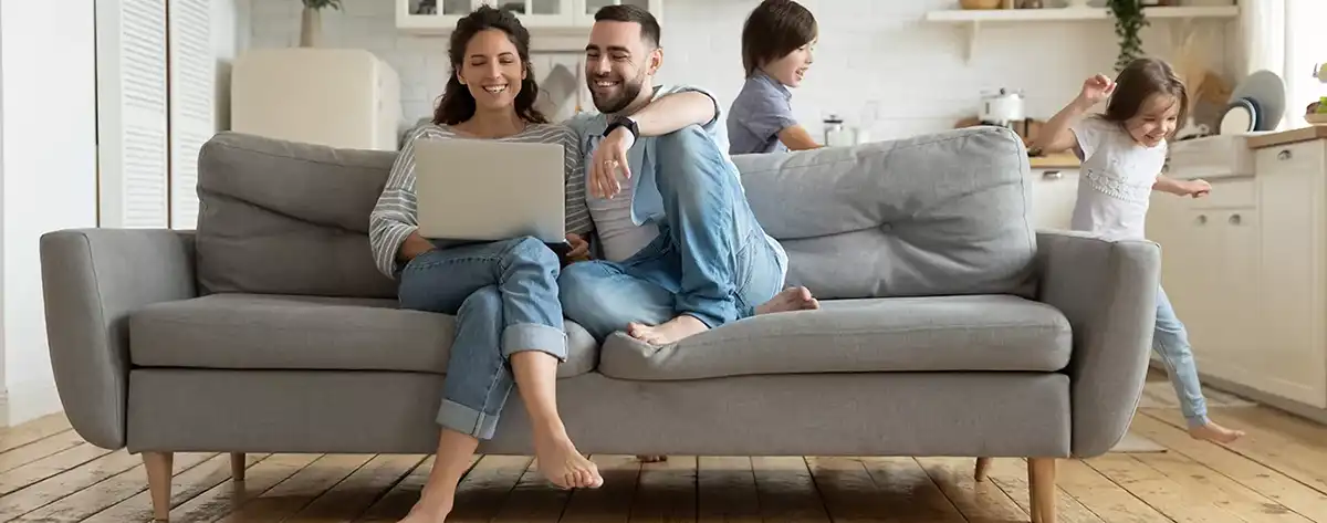 Family on sofa Saving Money On Air Conditioning This Summer